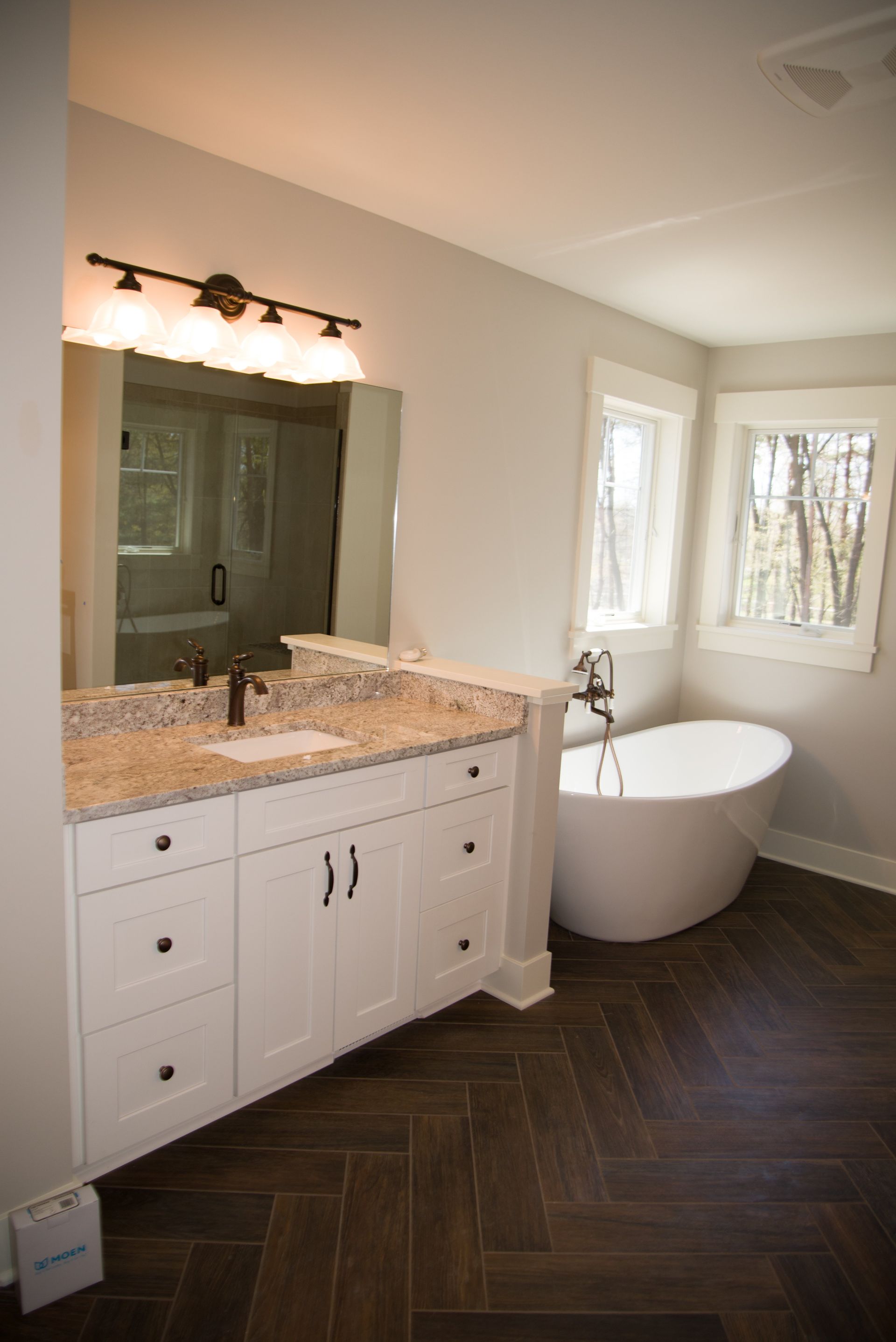 A bathroom with a tub , sink and mirror.