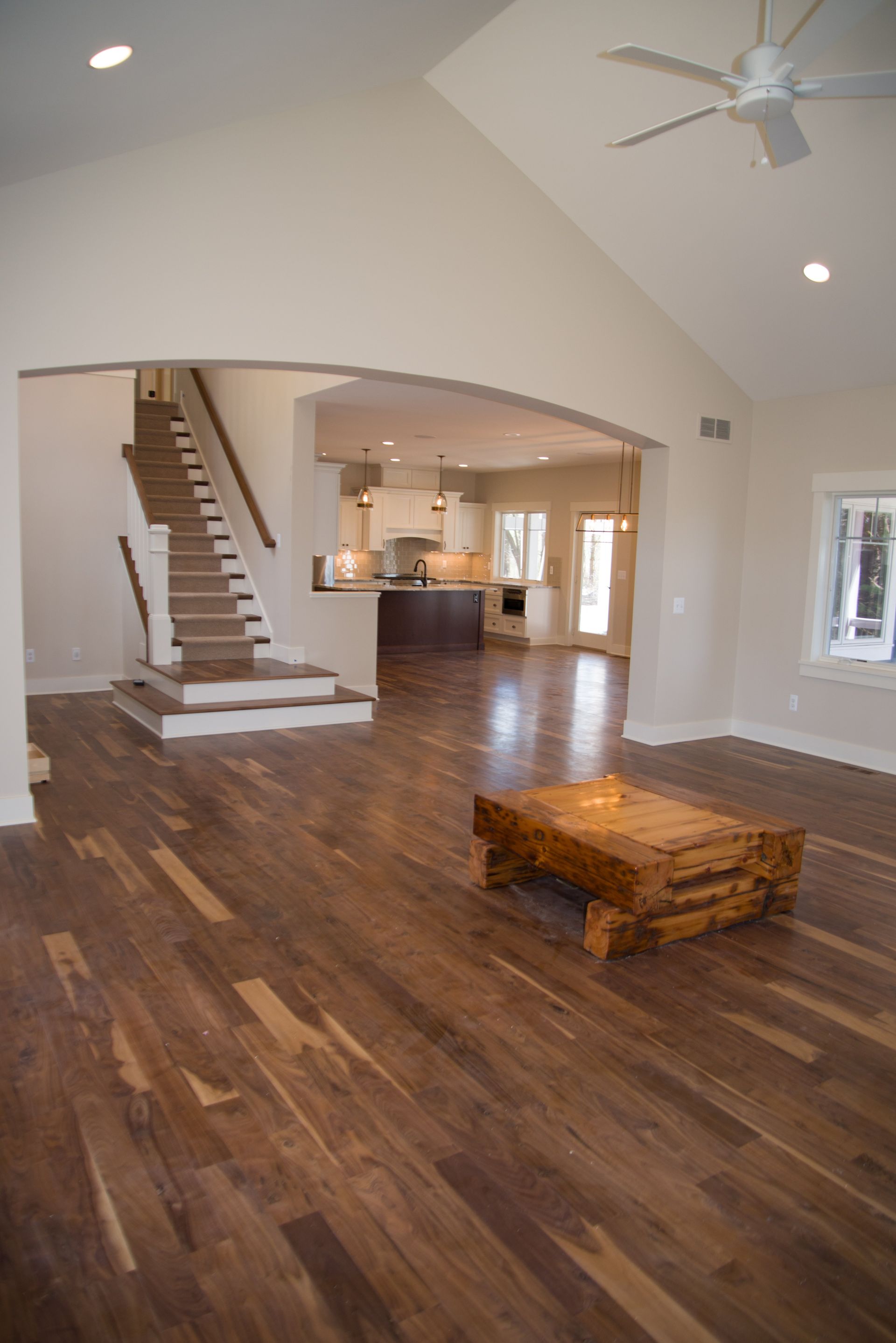 A living room with hardwood floors and a ceiling fan.