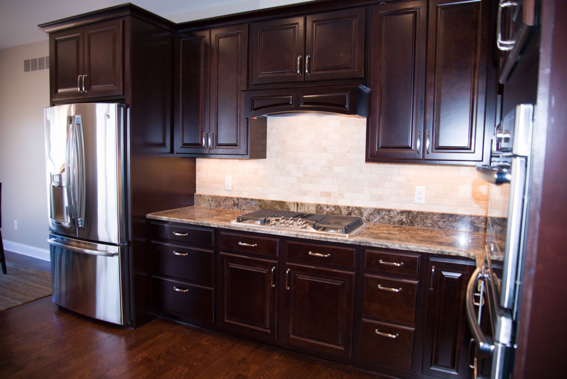 A kitchen with dark wood cabinets and stainless steel appliances
