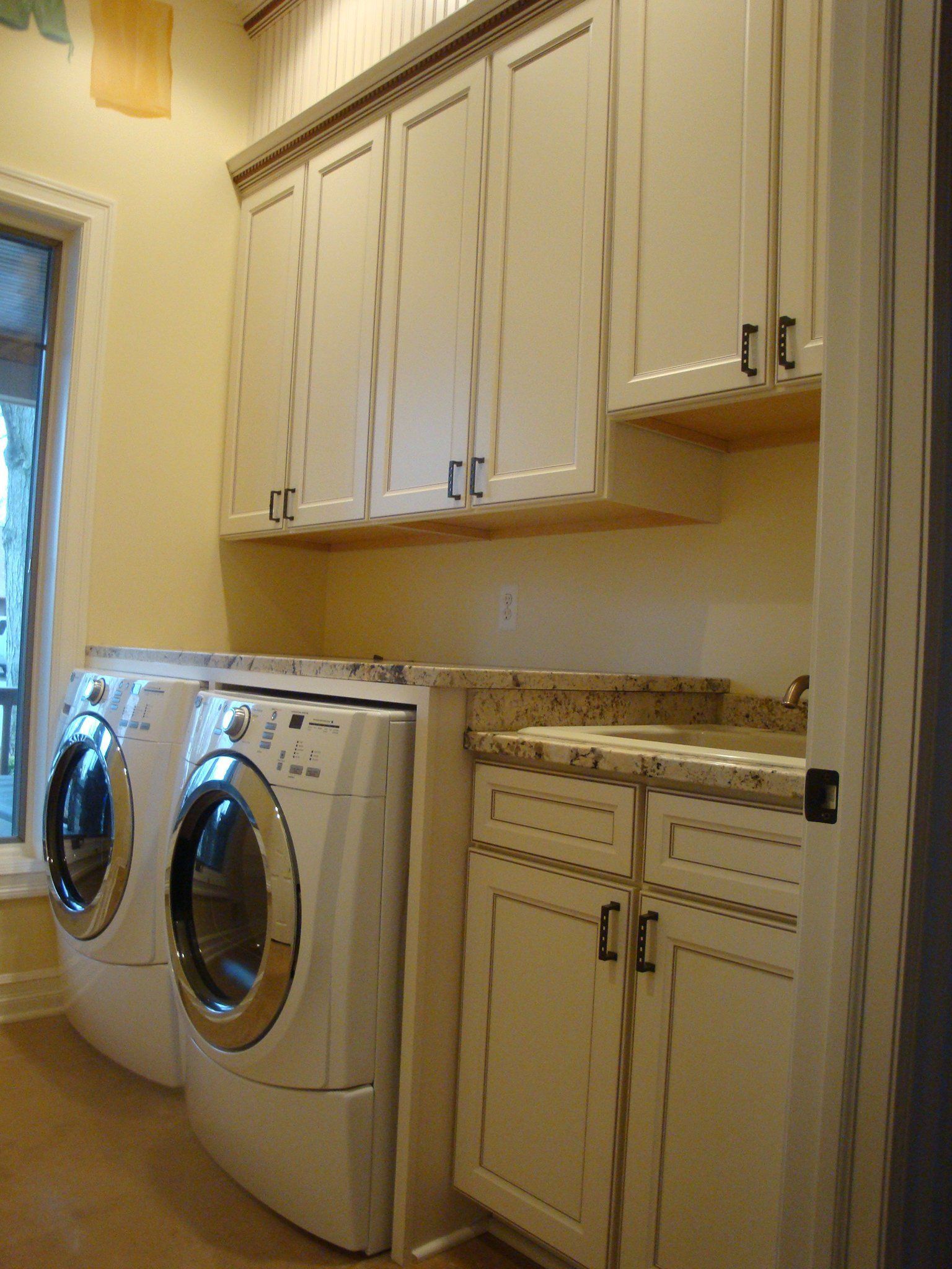 A laundry room with two washers and two dryers