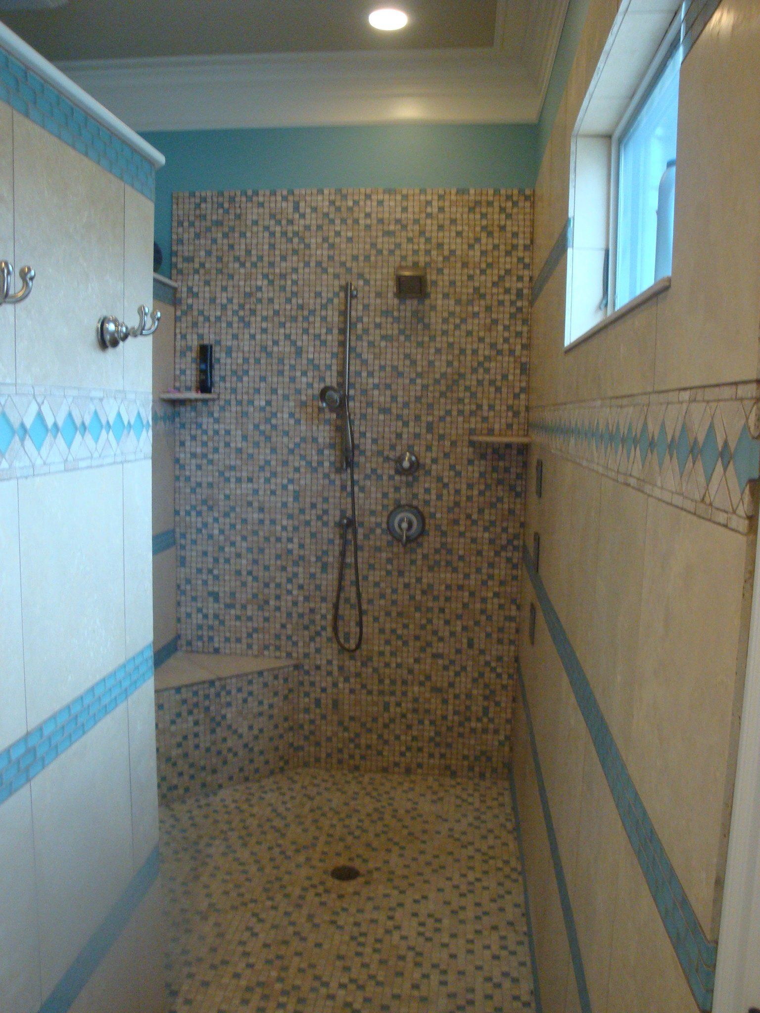 A bathroom with a walk in shower and a window
