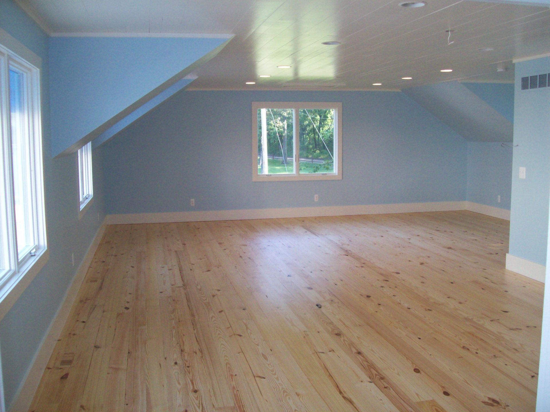 An empty room with wooden floors and blue walls
