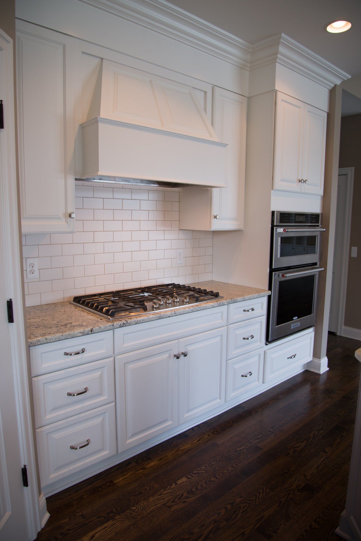 A kitchen with white cabinets and a stove top oven