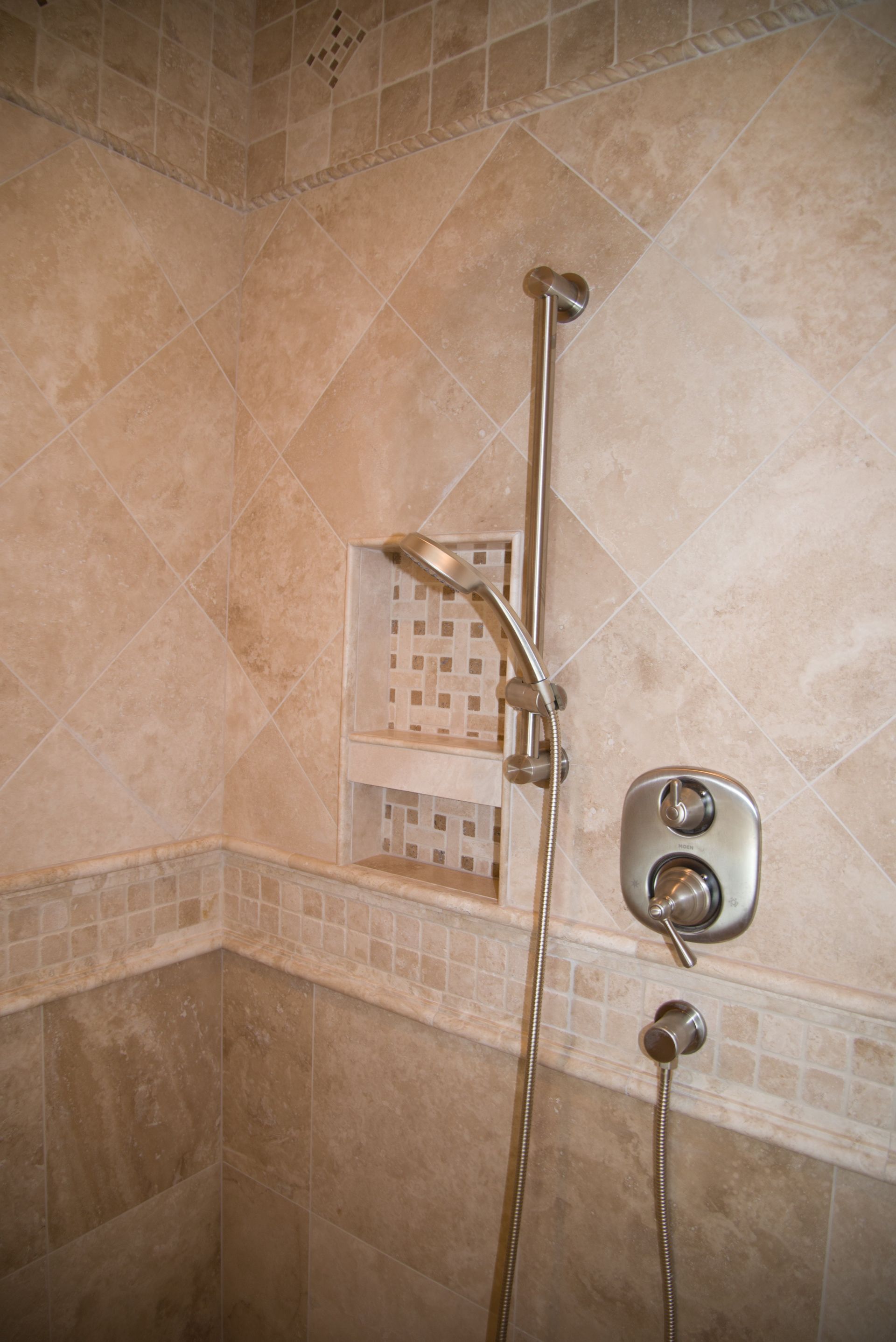 A close up of a shower head in a bathroom.