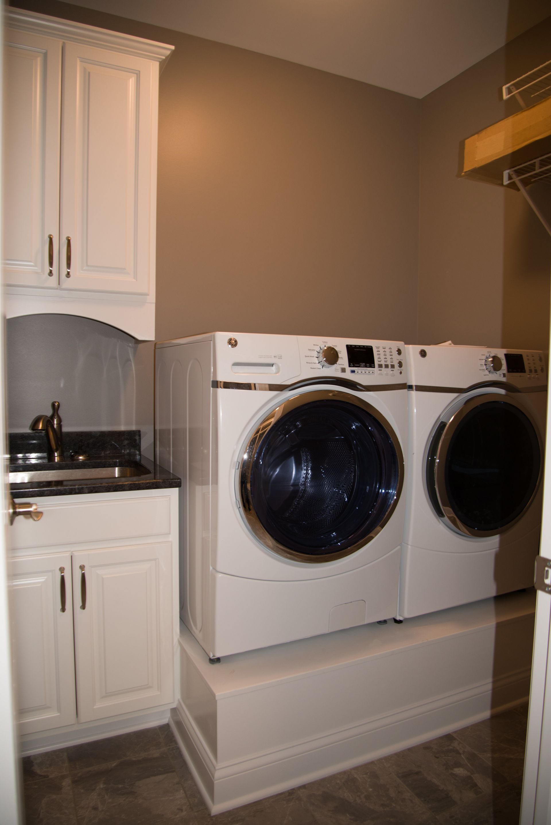A laundry room with a washer and dryer and a sink.