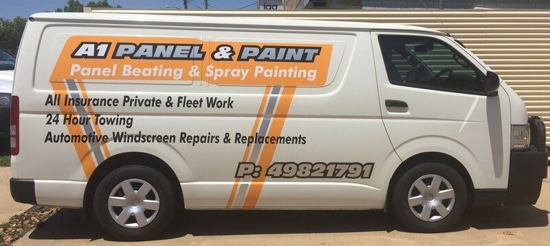 White Work Van With Orange-and-black A1 Panel & Paint Signage Parked on a Sandy Street — A1 Panel & Paint In Emerald, QLD