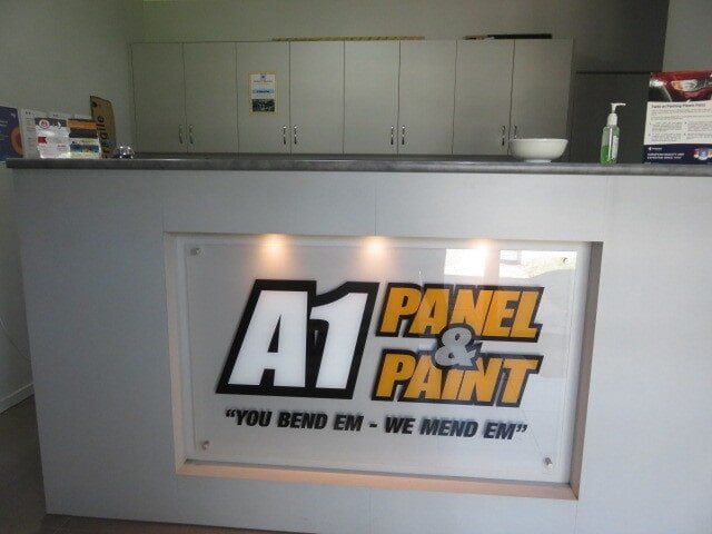 A1 Panel & Paint Auto Body Shop Counter With White Cabinets and Signage Behind It — A1 Panel & Paint In Emerald, QLD