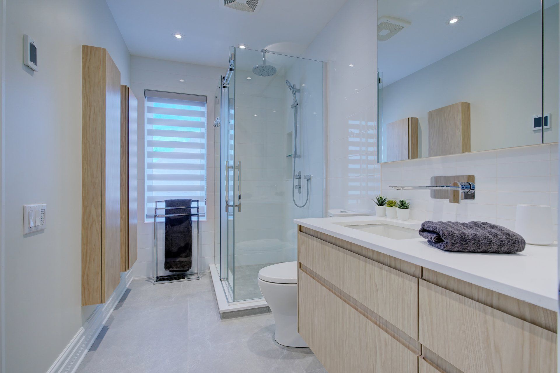 Une salle de bain avec WC, lavabo, miroir et douche à l'italienne.
