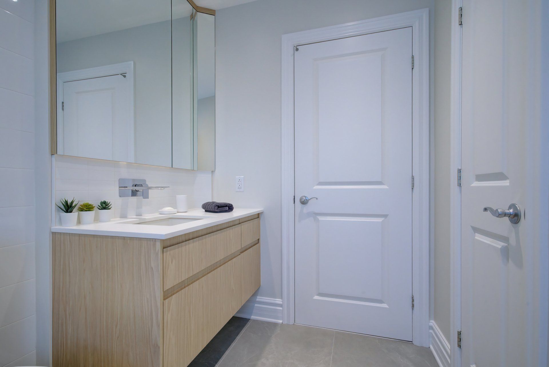 Une salle de bain avec lavabo , miroir et porte.