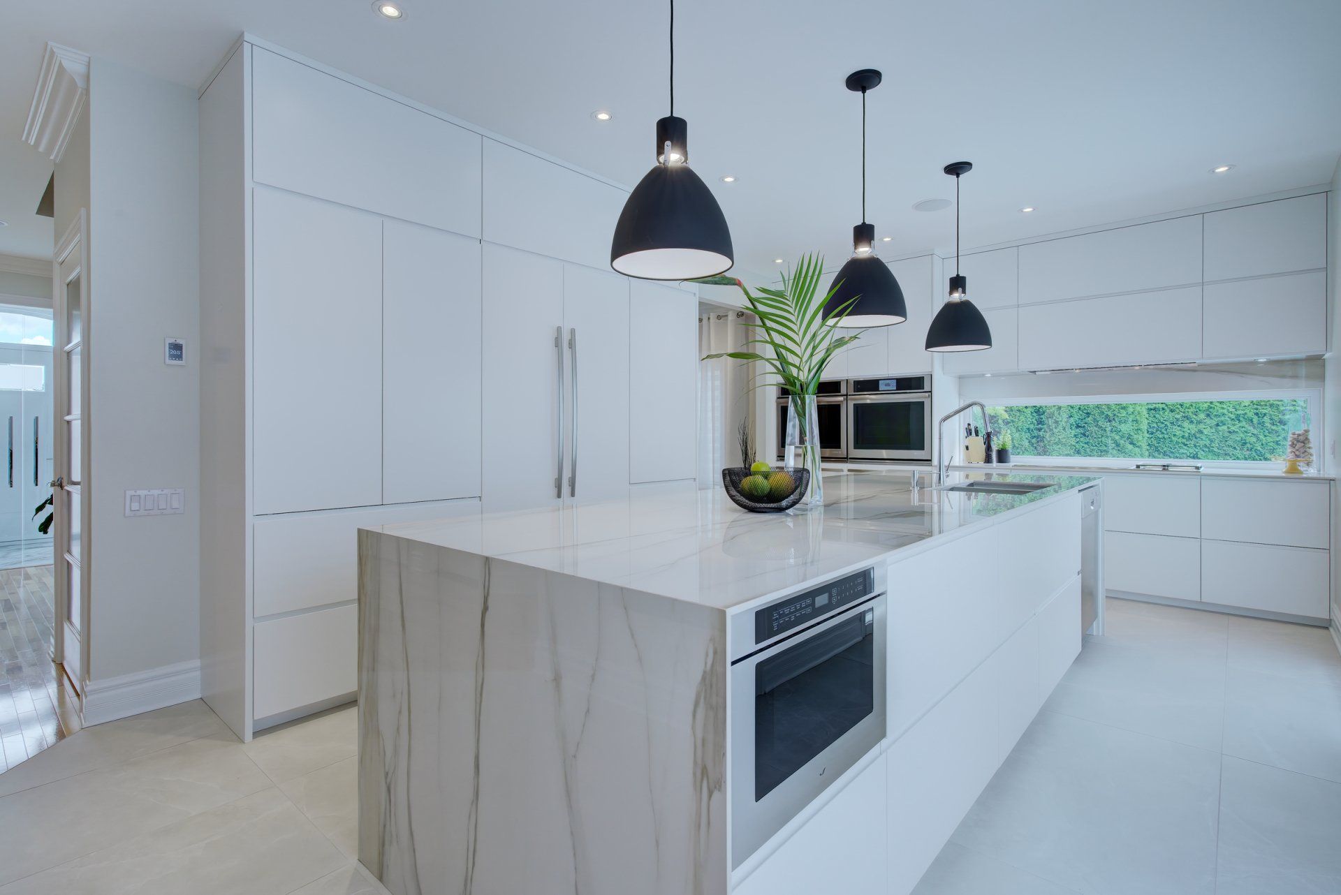 A kitchen with white cabinets and a large island in the middle.