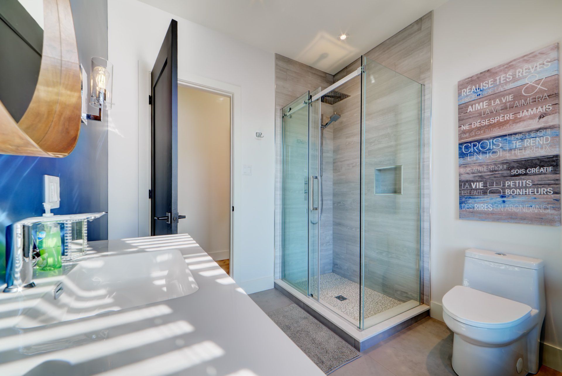 Une salle d'eau avec WC, lavabo et douche à l'italienne.