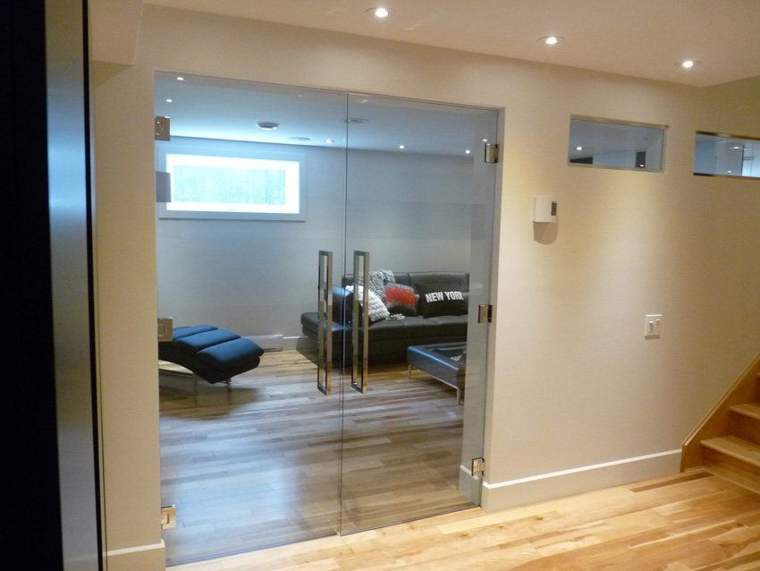 sous-sol avec plancher en bois clair et armoire à portes en verre