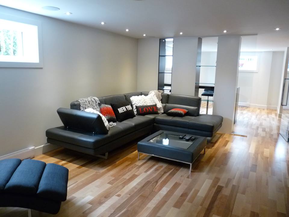 sous-sol avec parquet et canapé d'angle noir