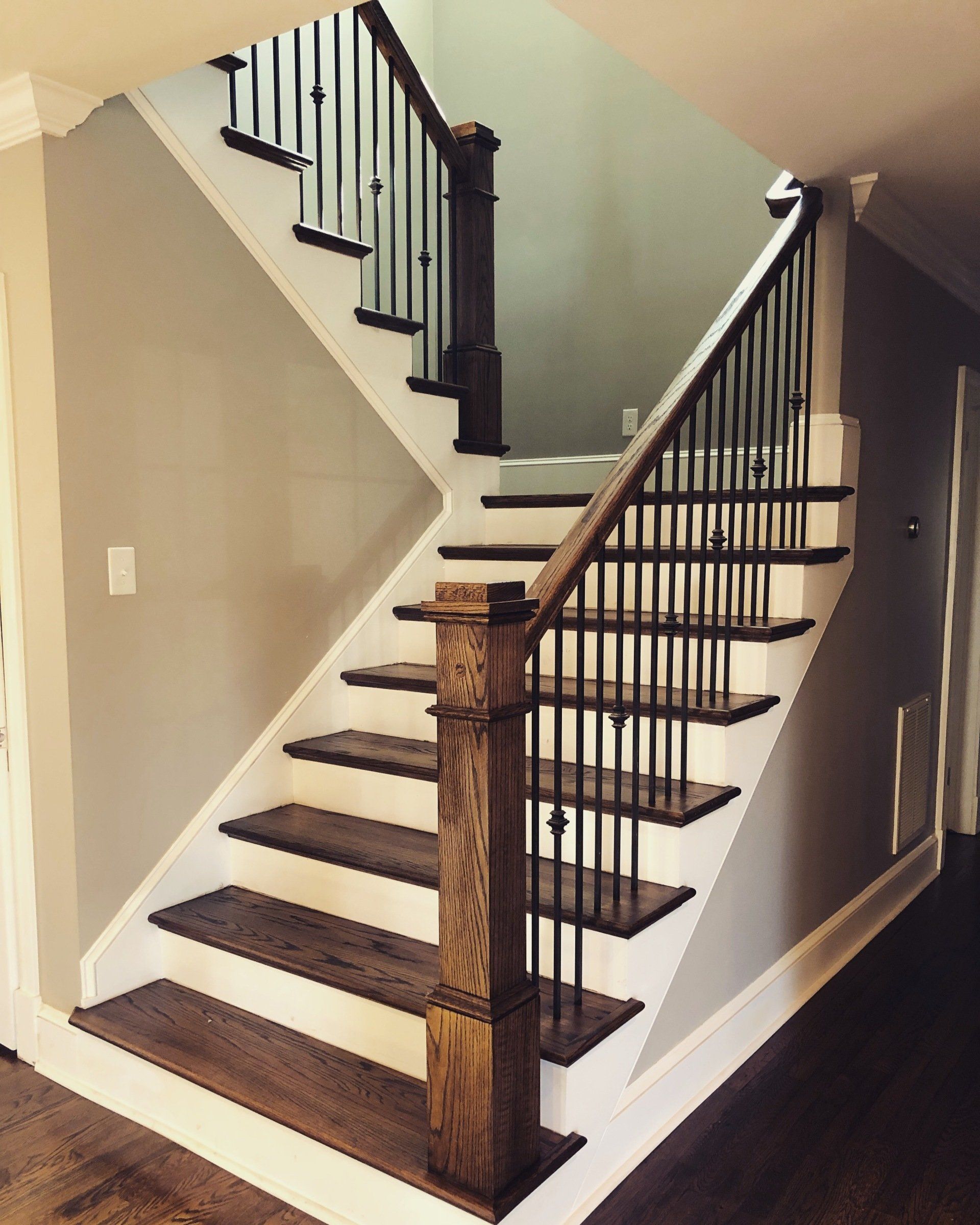 Custom staircase with wrought-iron balusters and stained wood handrail in Greenville, SC