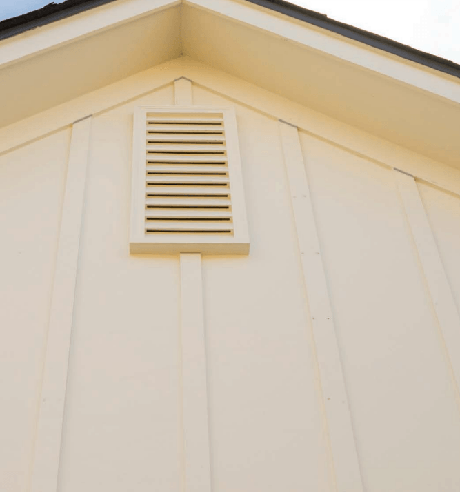 White house gable with a small cream-colored attic vent on the upper wall
