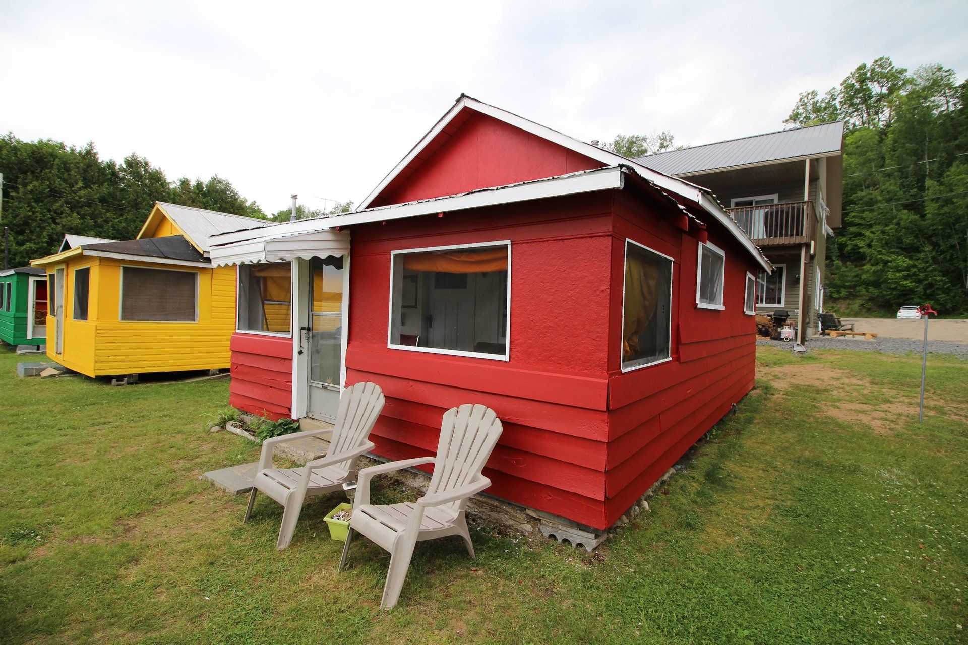 A red cabin with two chairs in front of it