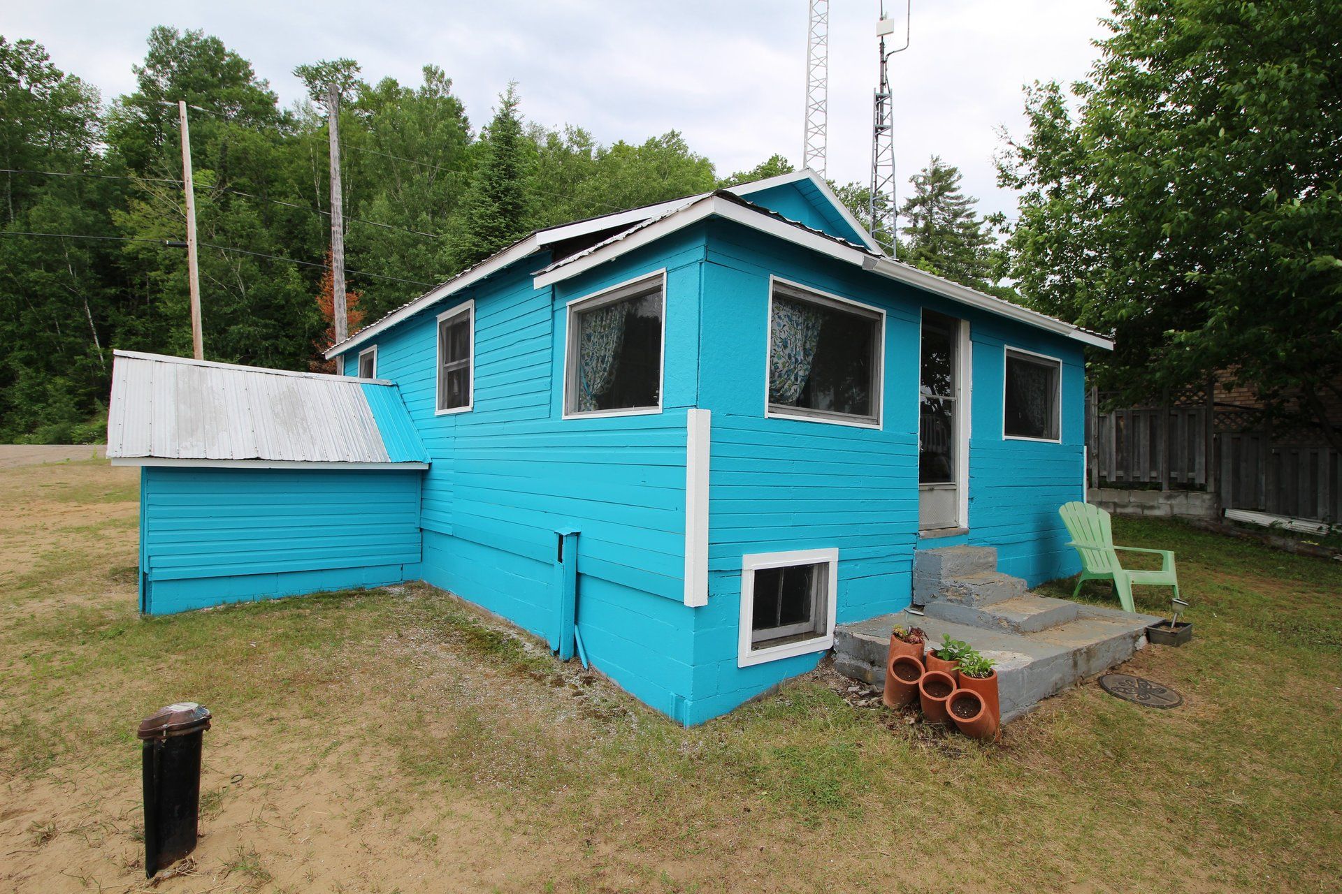 A blue house with a green chair in front of it