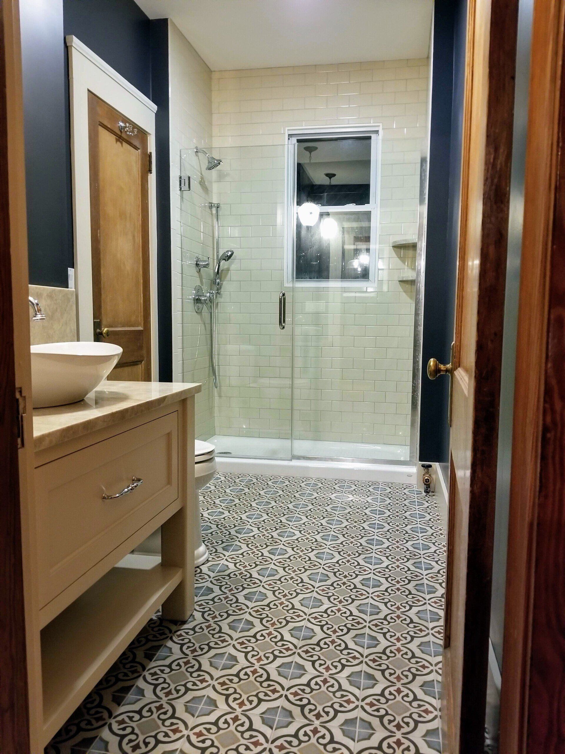 A bathroom with a sink and a walk in shower