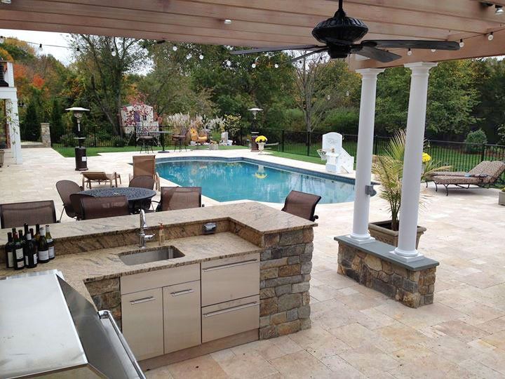 A patio with a kitchen and a swimming pool
