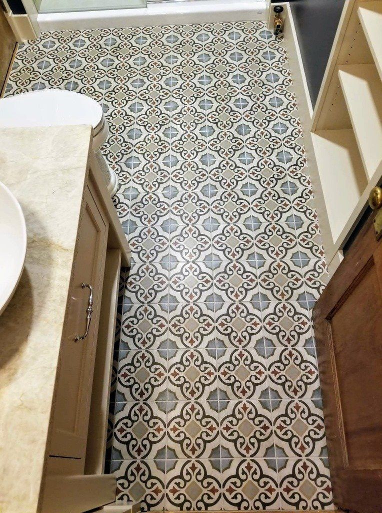 A bathroom with a tiled floor and a sink.
