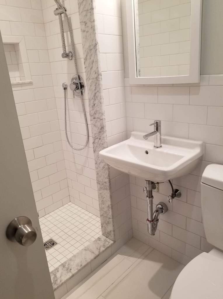A bathroom with a sink , toilet and shower.