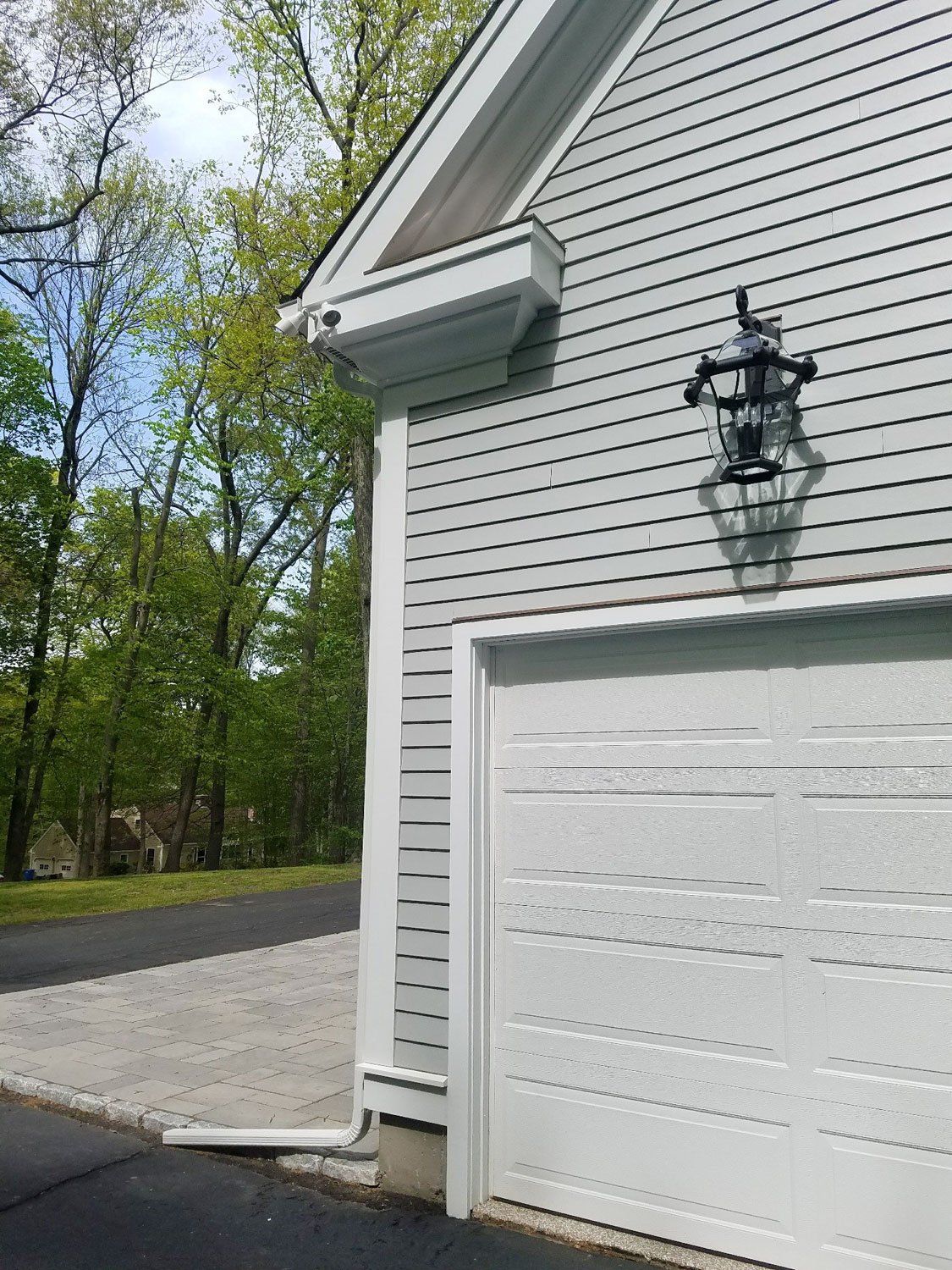 A white garage door is on the side of a house.
