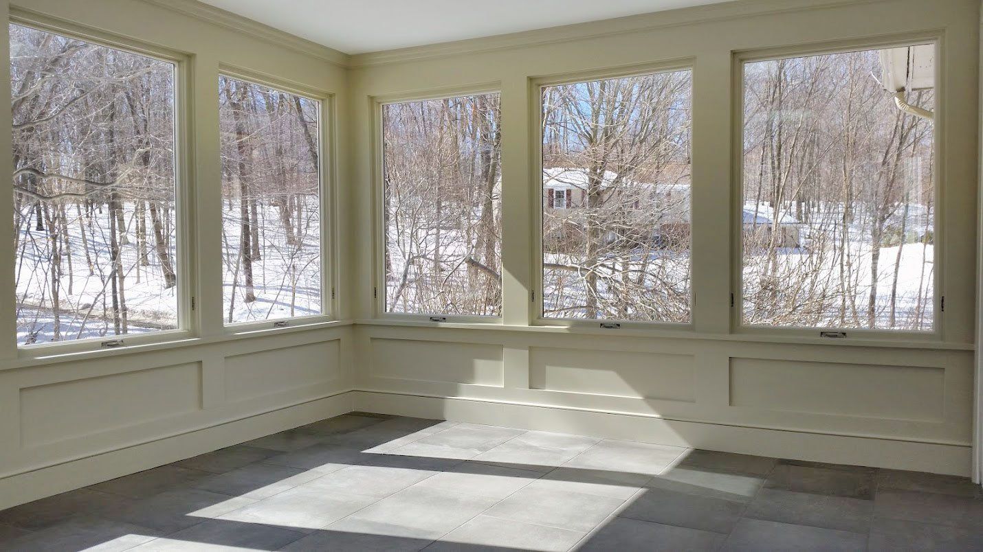 A room with a lot of windows and trees in the background