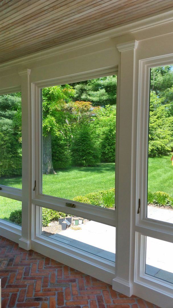 A room with a lot of windows and a view of a yard.