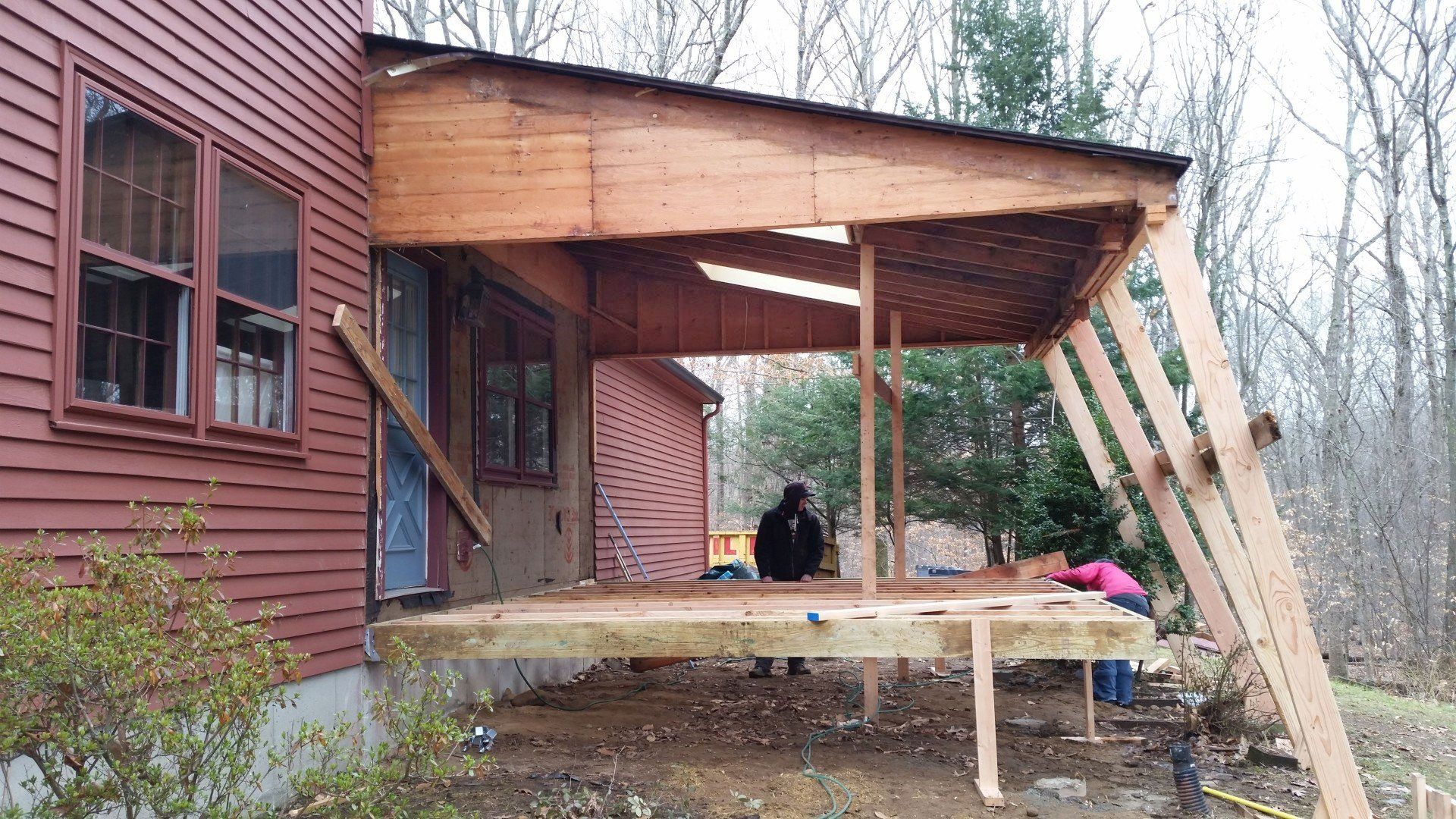 A wooden deck is being built on the side of a house.