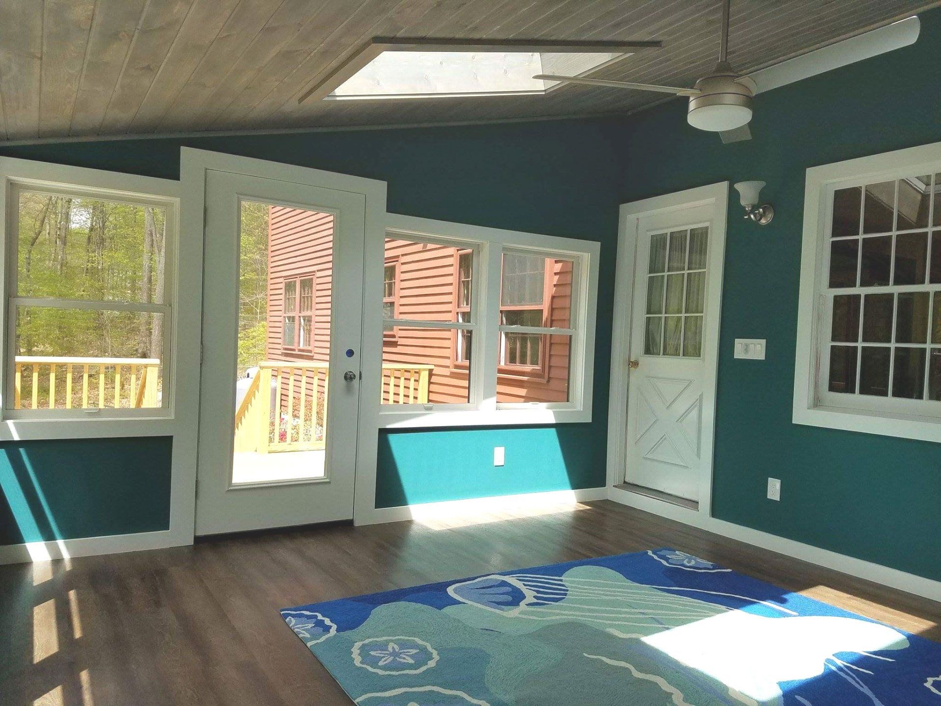 An empty room with a rug and a ceiling fan