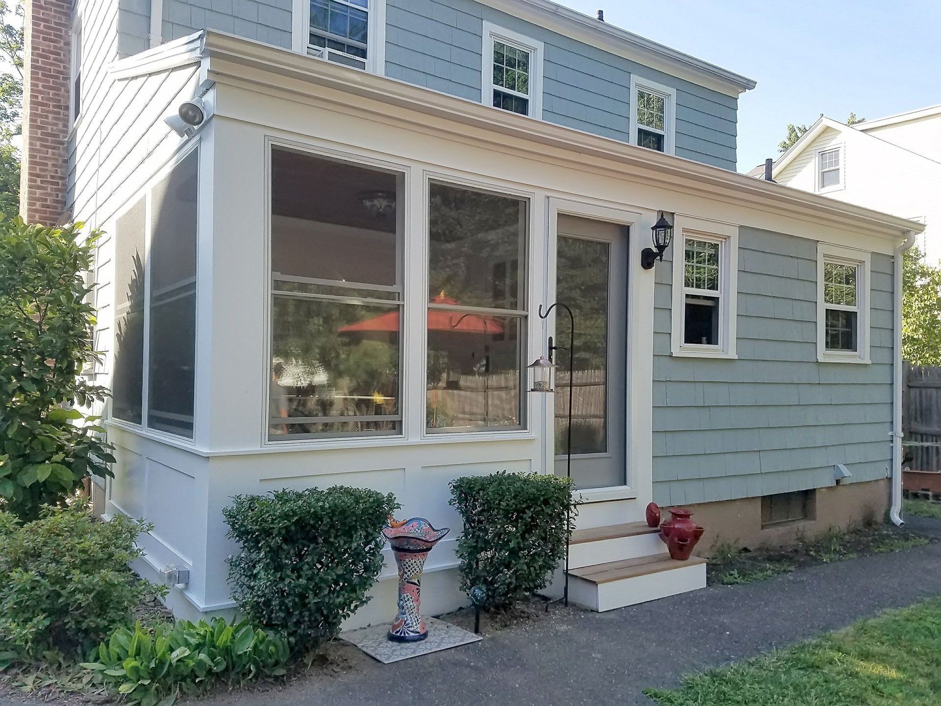 A house with a screened in porch and a bird bath
