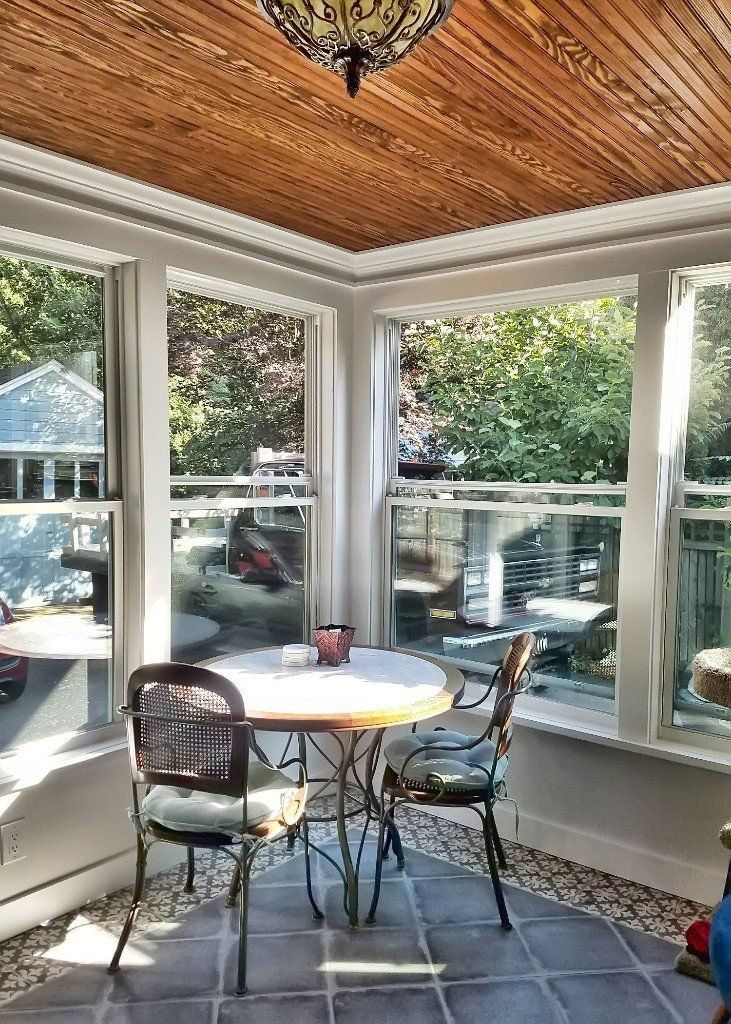 A sunroom with a table and chairs and lots of windows