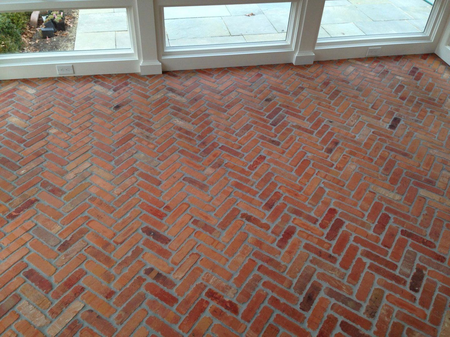 A brick floor with a herringbone pattern in a room