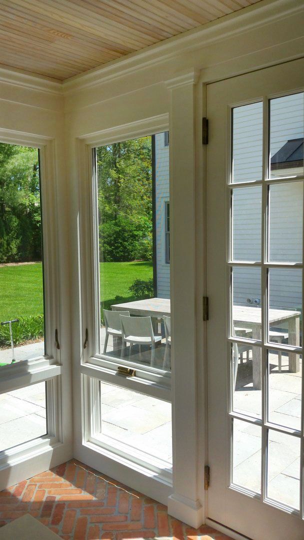 A room with a lot of windows and doors leading to a patio.