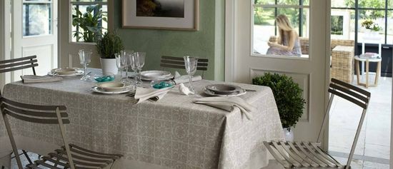 una tavola da pranzo apparecchiata con tovaglia grigia