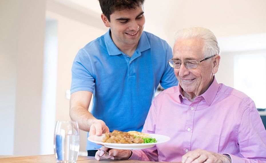 Professional Assistant Serving Meal To Old Man — Lawrenceville, GA — Professional and Quality Home Care Professional Assistant Serving Meal To Old Man — Lawrenceville, GA — Professional and Quality Home Care