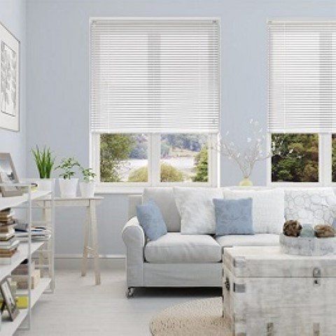 A living room with a white couch and a white trunk.