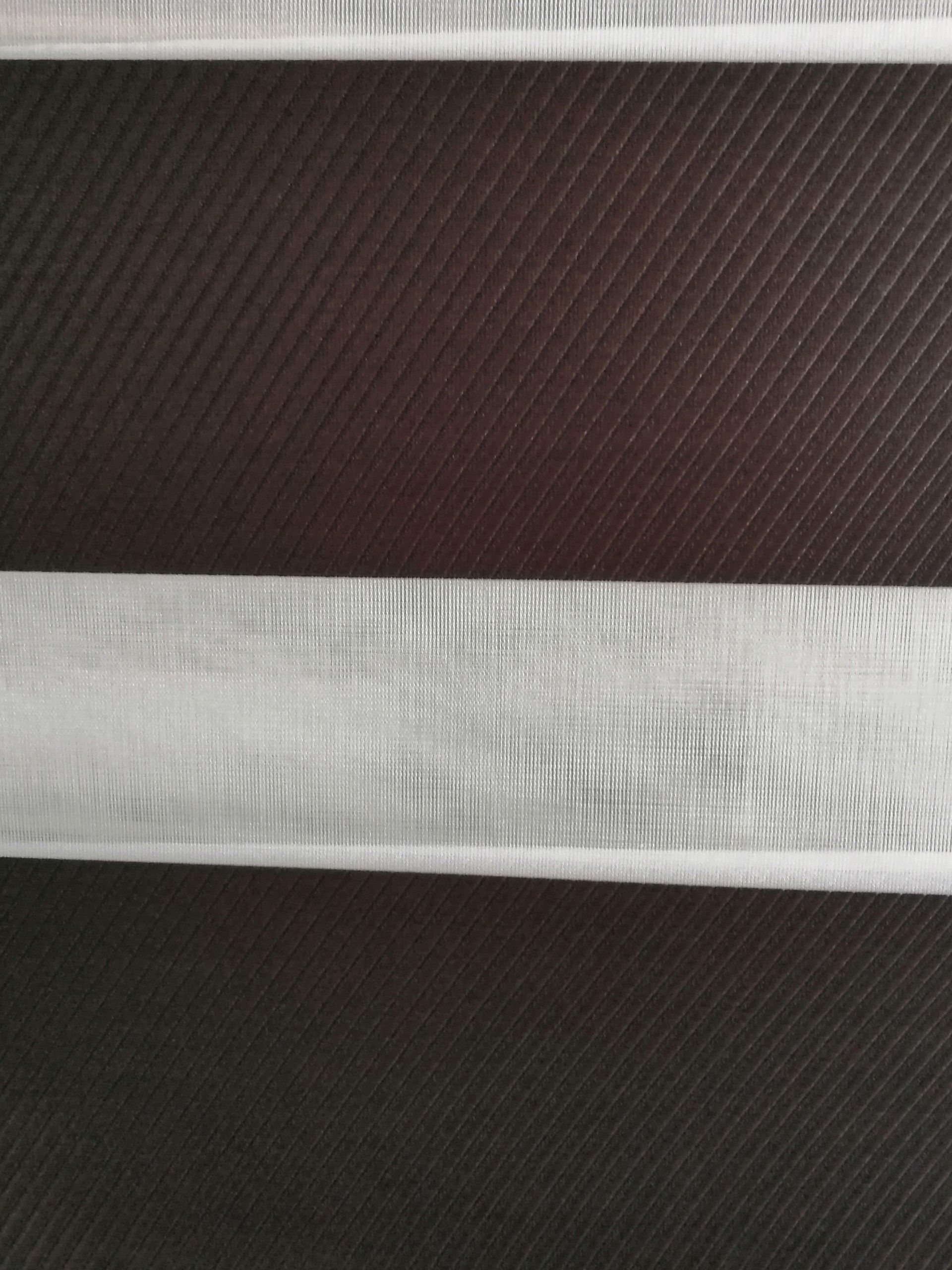 A close up of a white ribbon on a black background.