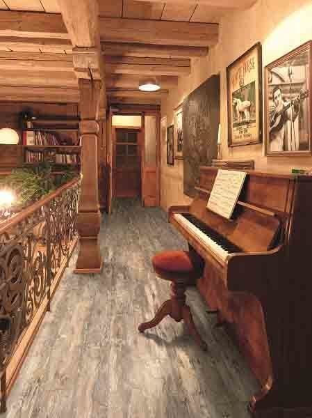 There is a piano in the middle of a hallway.