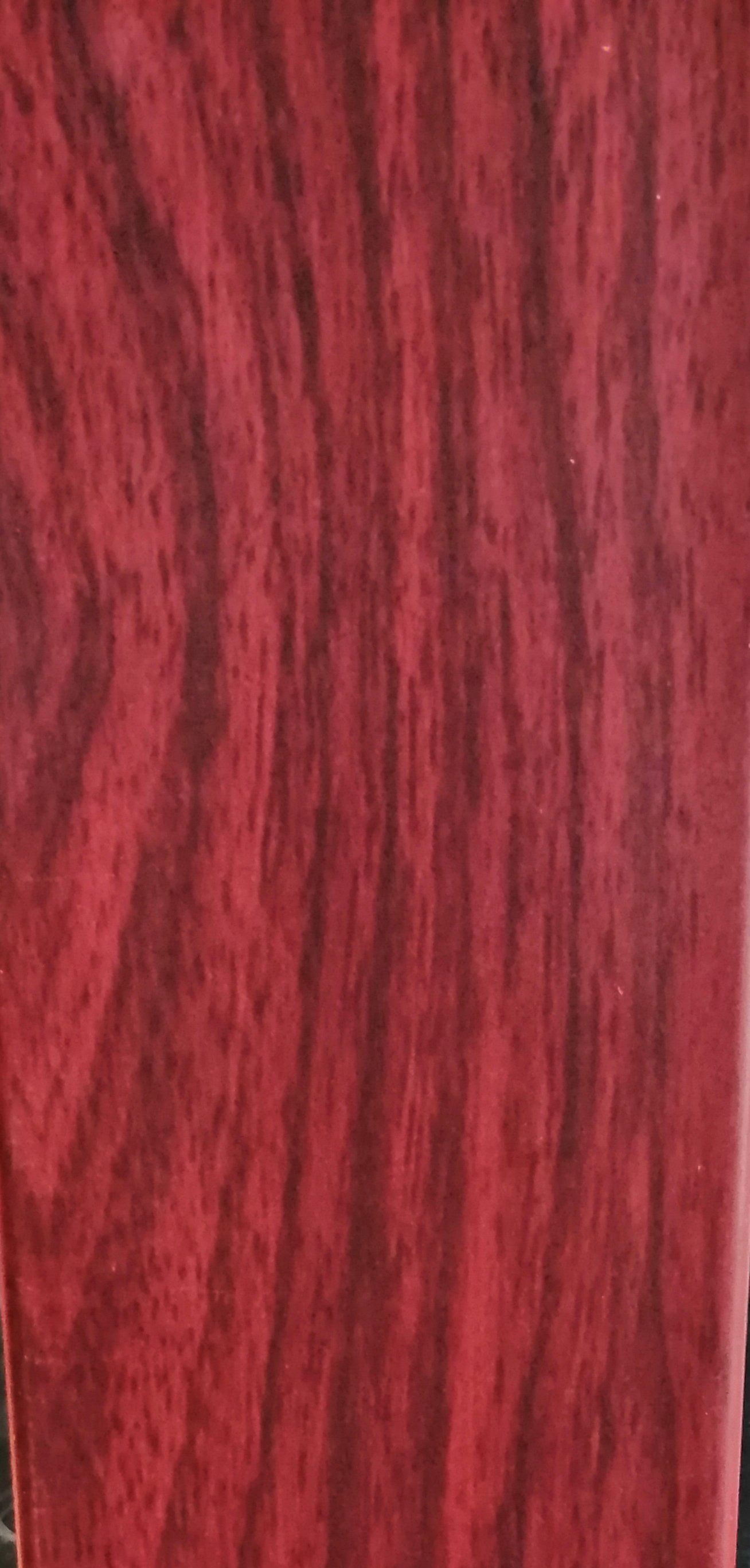 A close up of a red cloth with a wood grain texture.