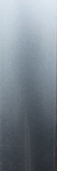 A close up of a stainless steel surface with a gray background.