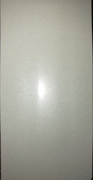 A close up of a white tile with a light shining through it.