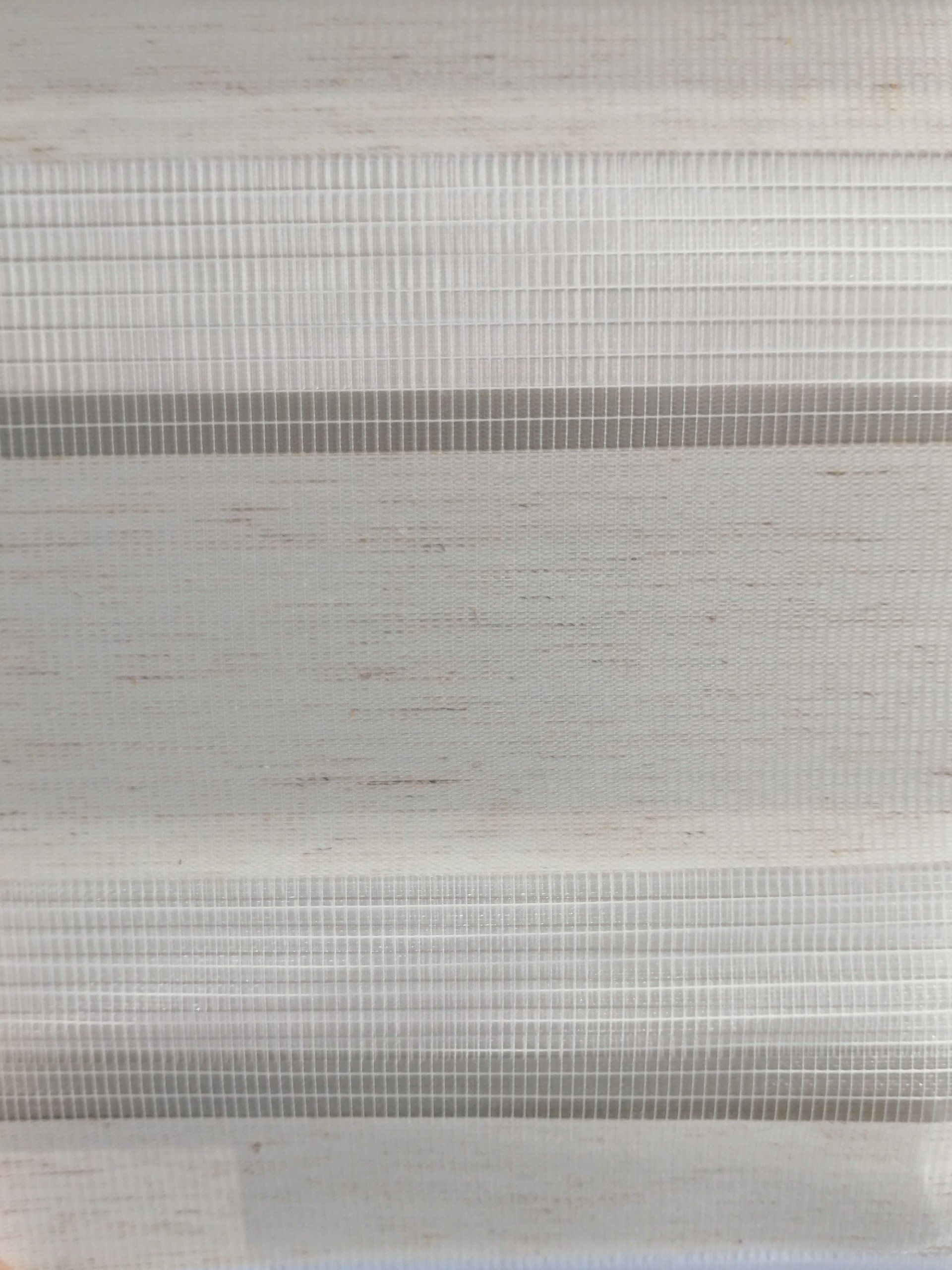 A close up of a white blind with a gray stripe on it.