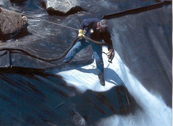 Man Spraying on Pond Liner — Vista, CA — Koiland Inc. Man Spraying on Pond Liner — Vista, CA — Koiland Inc.