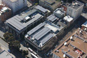 Aerial view of buildings with solar panels on rooftops.