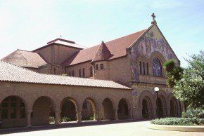 Stanford Memorial Church, beige stone building with arched walkway, red-tile roof, and cross on top.
