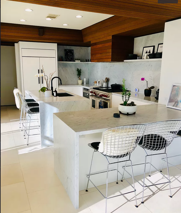 A kitchen with a large island and stools