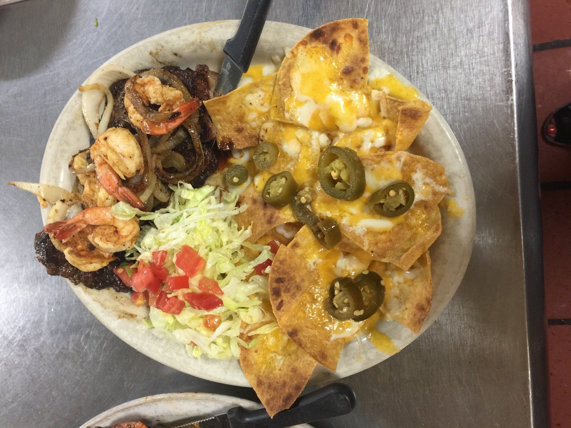 A plate of food with nachos and shrimp on a table.