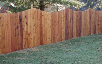 A wooden fence is sitting on top of a lush green lawn.