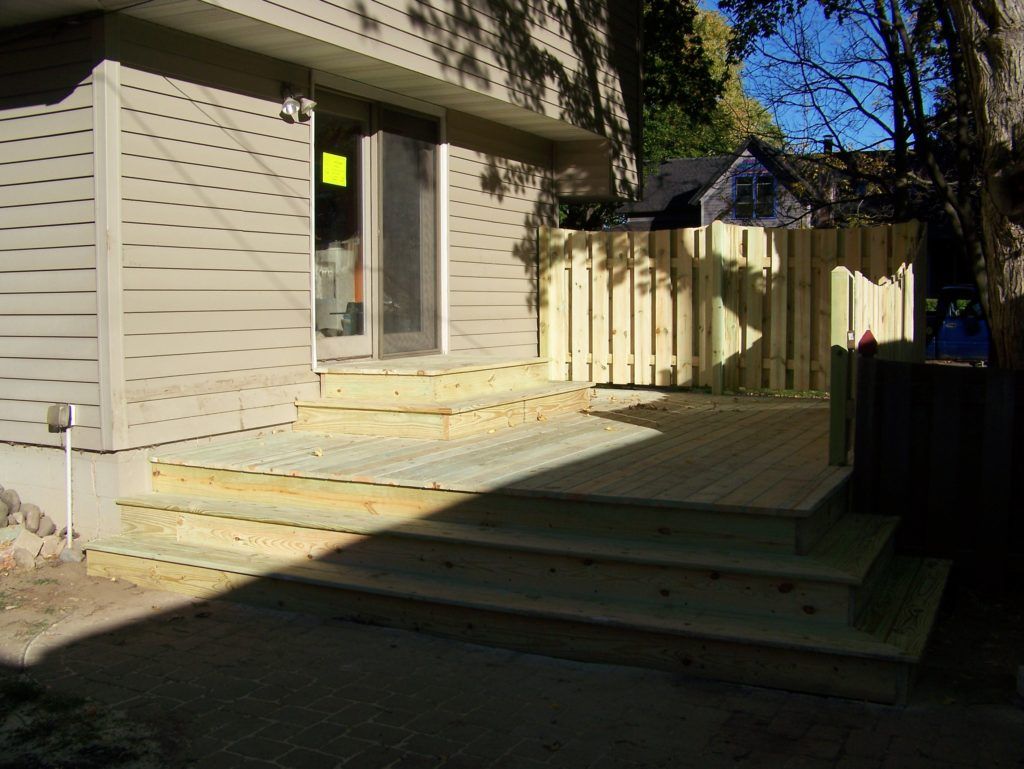  A house with a wooden deck and wooden privacy fence